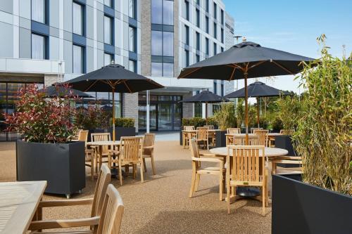 a patio with tables and chairs with umbrellas at Courtyard by Marriott Stoke on Trent Staffordshire in Stoke on Trent