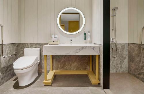a bathroom with a toilet and a sink and a mirror at Hilton Garden Inn Foshan Lishui-Free Shuttle Bus for Canton Fair in Foshan