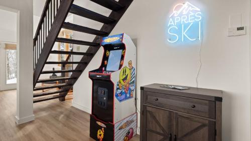 a arcade video game machine next to a staircase at Clyde's Cabin home in Warren