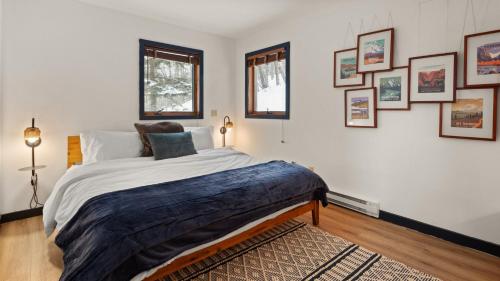 a bedroom with a large bed and pictures on the wall at Clyde's Cabin home in Warren