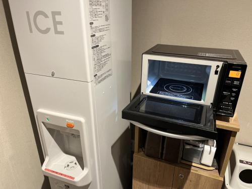 a microwave oven sitting on top of a refrigerator at Hotel Route Inn Grand Asahikawa Ekimae in Asahikawa
