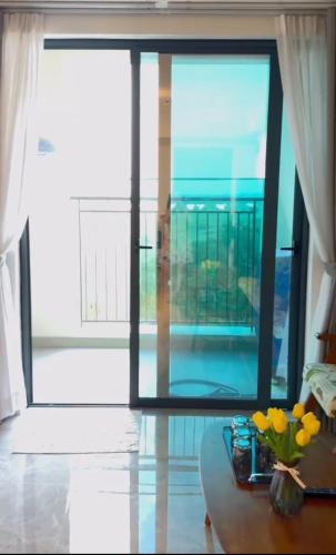 a room with a large window and a table with flowers at Swanbay - Căn Hộ 2PN in Cù Lao Ong Con