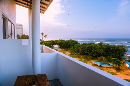 a balcony with a table and a view of the ocean at Mirissa Turtle Point Guest in Mirissa