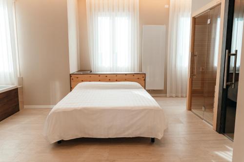 a bedroom with a bed in a room with windows at Wine & Wellness in Villalta