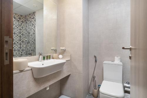 a bathroom with a sink and a toilet and a mirror at Lovely Studio & Budget Friendly in Dubai