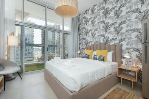 a bedroom with a large bed and a wall of windows at Lovely Studio & Budget Friendly in Dubai