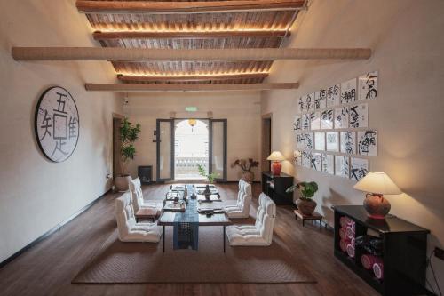 a living room with a table and white chairs at 湄洲岛泊澜清风民宿 in Putian