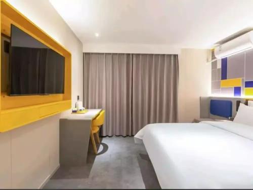 a bedroom with a bed and a desk and a television at 7Days Inn Xi'an East Street in Xi'an
