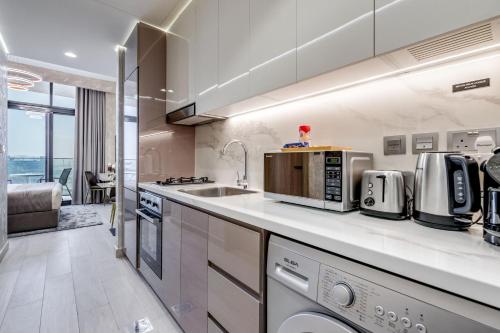 a kitchen with a sink and a microwave at GLOBALSTAY Azizi Riviera 48 in Dubai