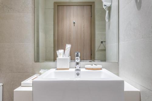 a bathroom with a white sink and a mirror at GLOBALSTAY Azizi Riviera 48 in Dubai