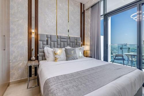 a bedroom with a large bed and a balcony at GLOBALSTAY Azizi Riviera 48 in Dubai