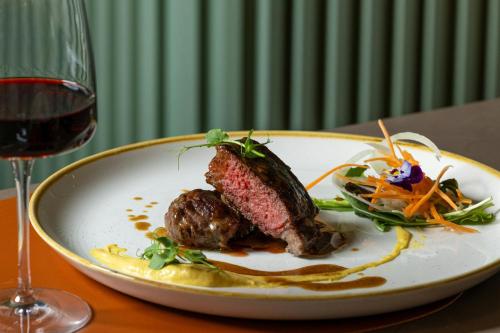 a plate of food on a table next to a glass of wine at Courtyard by Marriott Milano Linate in Milan