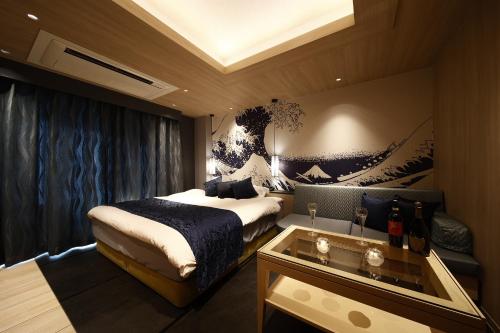 a hotel room with a bed and a glass table at ホテル リッド 男塾ホテルグループ in Hikone