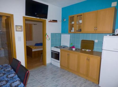 a kitchen with a white refrigerator and a stove at Beachfront Apartments Plaža in Ivan Dolac