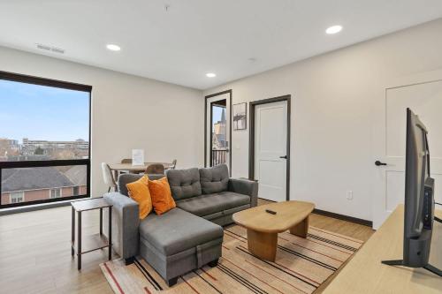 a living room with a couch and a tv at CozySuites Mass w parking lounge & roof deck #26 in Indianapolis