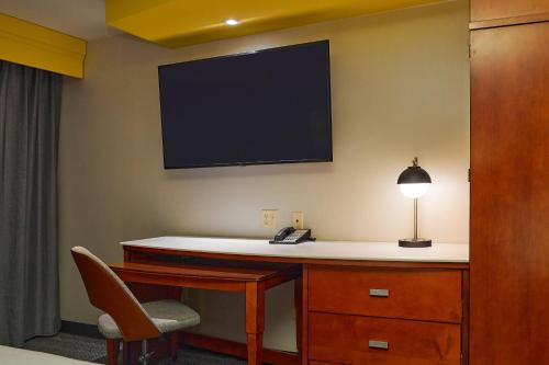 a room with a desk with a television on the wall at Courtyard Medford Airport in Medford