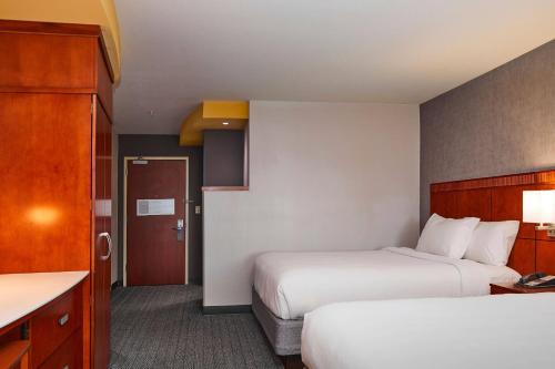 a hotel room with two beds and a kitchen at Courtyard Medford Airport in Medford