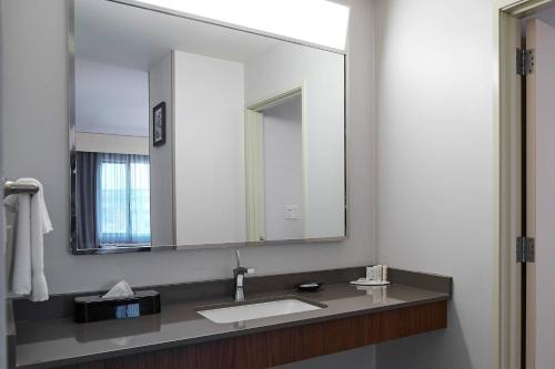 a bathroom with a sink and a large mirror at Courtyard Medford Airport in Medford