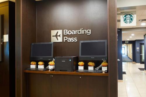 a lobby with two computer monitors on a counter at Courtyard Medford Airport in Medford