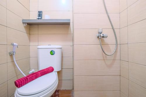 une salle de bain avec des toilettes blanches et une douche dans l'établissement Cozy Living and Homey Studio Apartment at Margonda Residence 5 By Travelio, à Depok