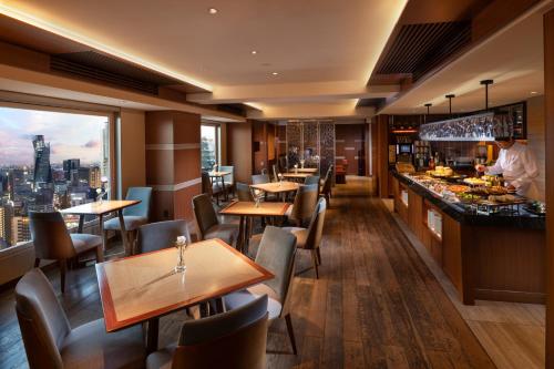 a restaurant with tables and chairs and a bar at Hilton Nagoya Hotel in Nagoya