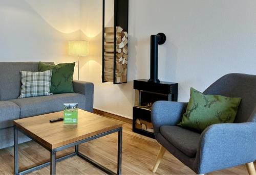 a living room with two chairs and a coffee table at Hirschzauber A9 Montana Haus in Oberstdorf