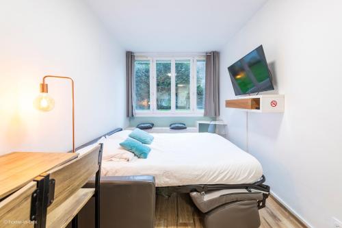 - une chambre à l'hôpital avec un lit et une télévision dans l'établissement Studio Moderne au coeur de Paris, à Paris