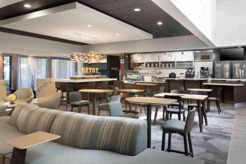 Un restaurante con mesas y sillas y un bar. en Courtyard Miami Airport West Doral, en Miami