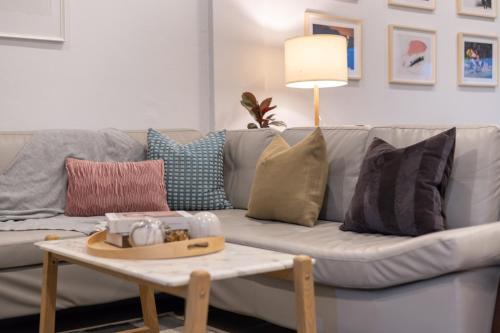 a living room with a couch with pillows and a table at Spacious Haven Chatuchak Market 5BR 10 Sleeps RB1 in Ban Zong Katiam