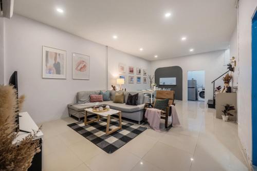 a living room with a couch and a table at Spacious Haven Chatuchak Market 5BR 10 Sleeps RB1 in Ban Zong Katiam