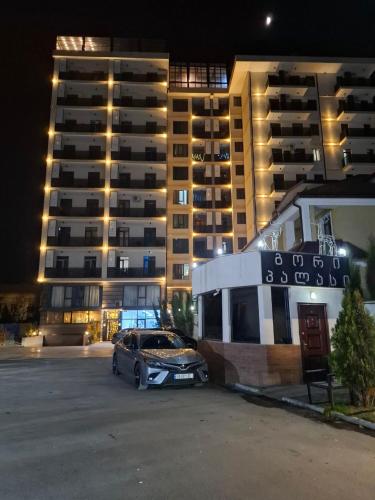a car parked in a parking lot in front of a building at Gori palace in Gori