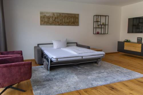 een bed in een kamer met een bank en een stoel bij Moselhaus Krieger in Traben-Trarbach