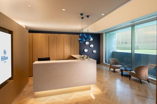 an office lobby with a reception desk and chairs at Hilton Nagoya Hotel in Nagoya
