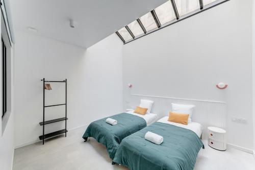 two beds in a room with white walls at NOCNOC L'Office in Lyon