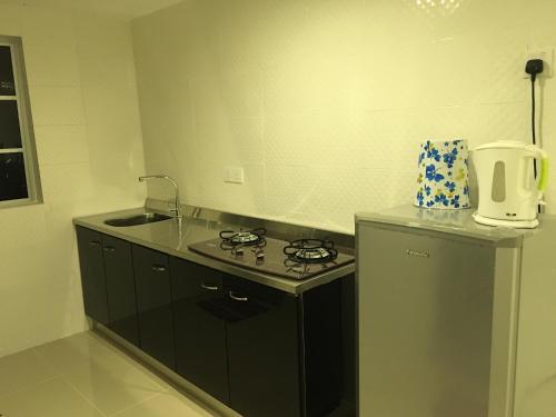a small kitchen with a stove and a sink at Sri Kilim Resthouse and Homestay Langkawi in Kilim