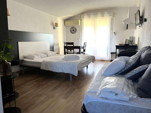 une chambre avec deux lits et une table et une fenêtre dans l'établissement SAINT FLORENT - Studio 3 pers balcon vue mer FLO300.251, à Saint-Florent