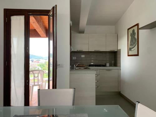 a kitchen with a table and a view of a balcony at Nel Bel Mezzo della Toscana in Poggibonsi