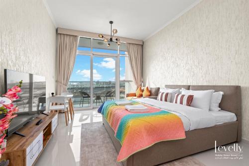 a bedroom with a large bed with a colorful blanket at Luxury Studio in DAMAC Hills with Premium Amenities in Dubai