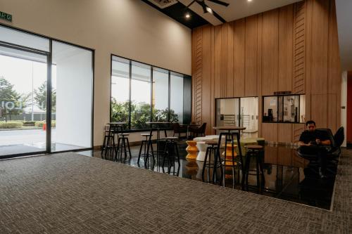 a man sitting at a bar in a room with windows at Wonderland Loft Sunway Grid Kid Friendly by Our Stay in Iskandar Puteri
