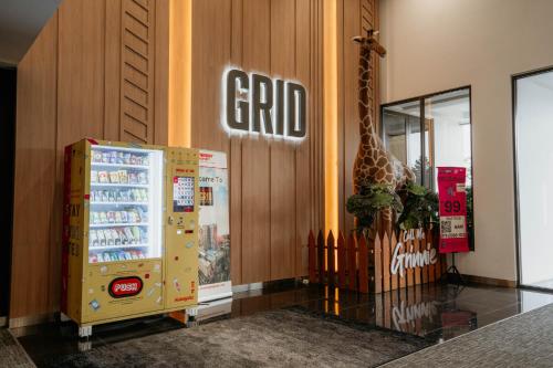 a giraffe is standing in a store with a refrigerator at Wonderland Loft Sunway Grid Kid Friendly by Our Stay in Iskandar Puteri