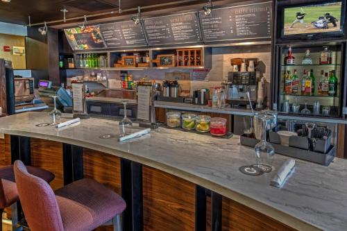 a bar in a restaurant with a counter and chairs at Courtyard Memphis Germantown in Memphis
