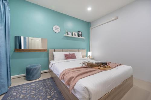 a bedroom with a large bed with a blue wall at Spacious Haven Chatuchak Market 5BR 10 Sleeps RB1 in Ban Zong Katiam