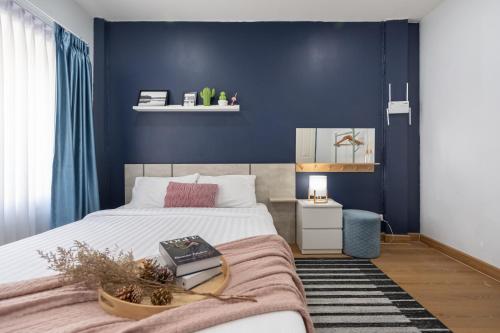a bedroom with a bed and a blue wall at Spacious Haven Chatuchak Market 5BR 10 Sleeps RB1 in Ban Zong Katiam