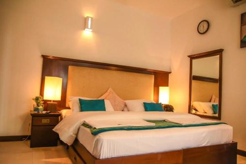 a bedroom with a large bed with a large mirror at Amara White Villa in Ahungalla