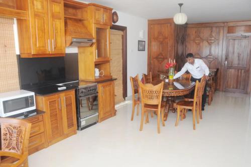 a man sitting at a table in a kitchen at Amara White Villa in Ahungalla