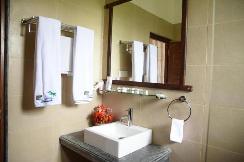 a bathroom with a white sink and a mirror at Amara White Villa in Ahungalla