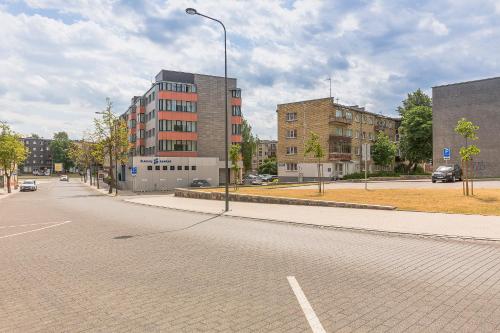 an empty city street with buildings and a street light at Town Square Apartment in Panevėžys