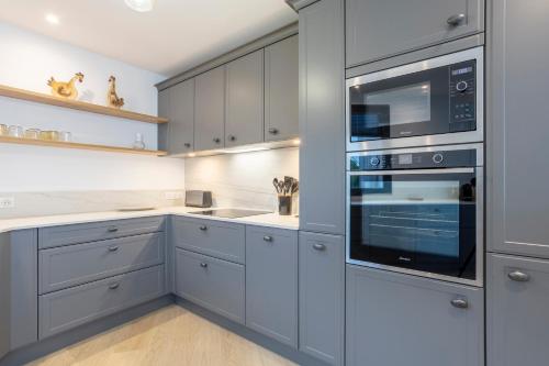 La cuisine est équipée de placards gris et d'un four noir. dans l'établissement Villa Dune - 180m de la plage, à Penmarcʼh
