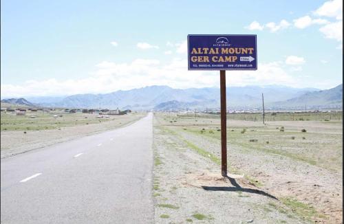 a sign on the side of a road in the desert at Altai Mount Camp in Ölgiy