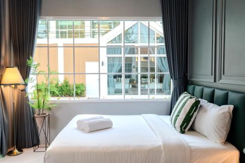 a bed in a room with a large window at The Sand and I Private Pool Villa Huahin in Hua Hin